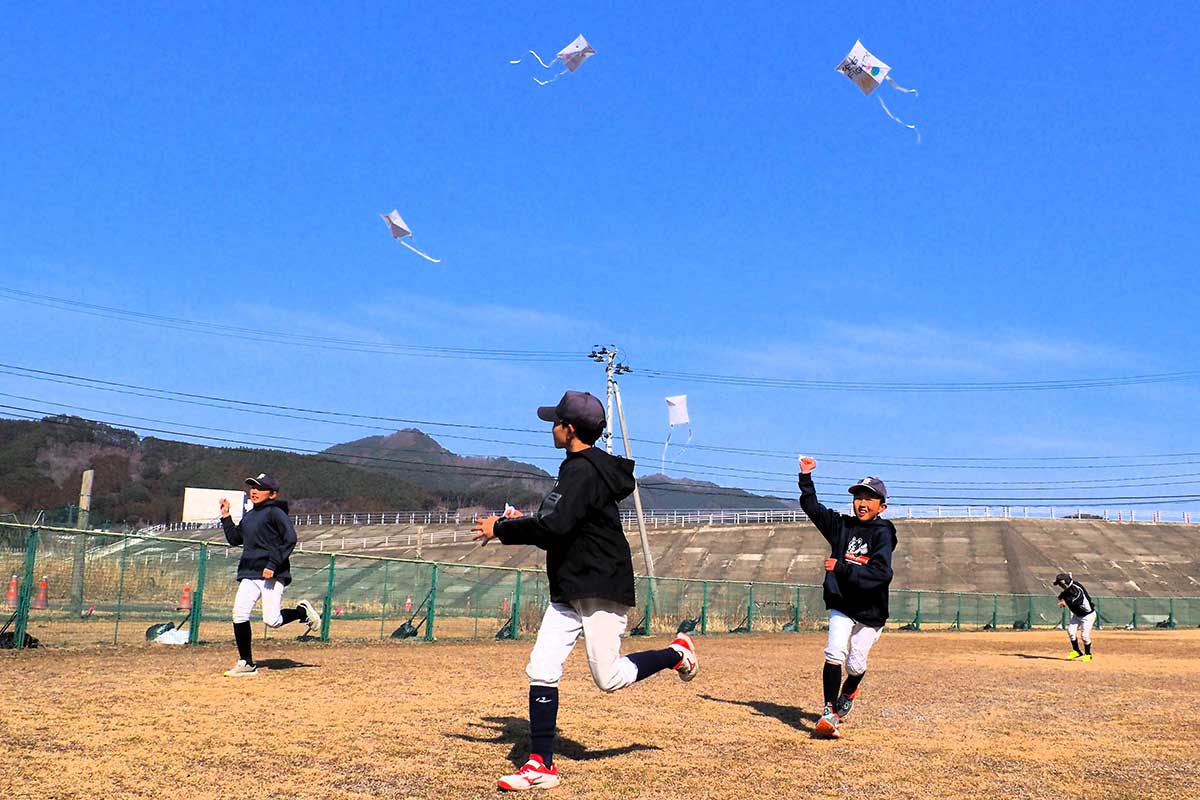 青空の下、平和の願いを込めたたこを飛ばす子どもたち