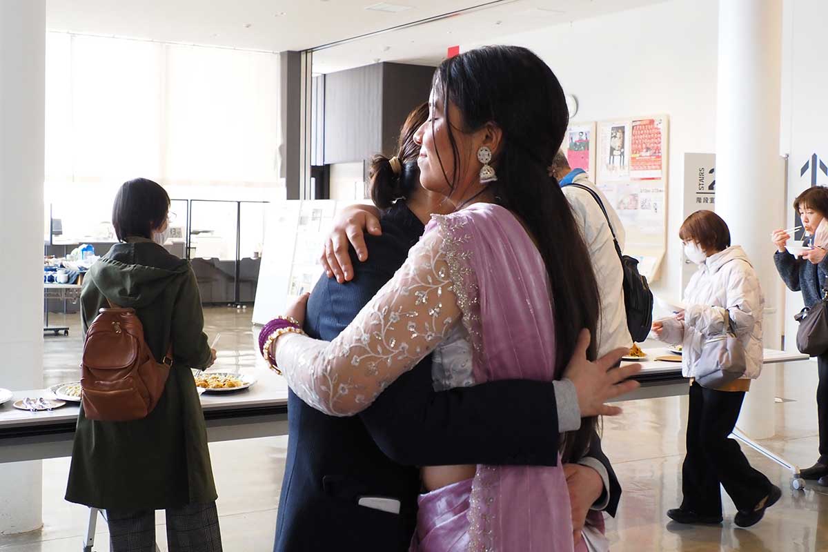 抱き合って別れを惜しむ卒業生と地域住民