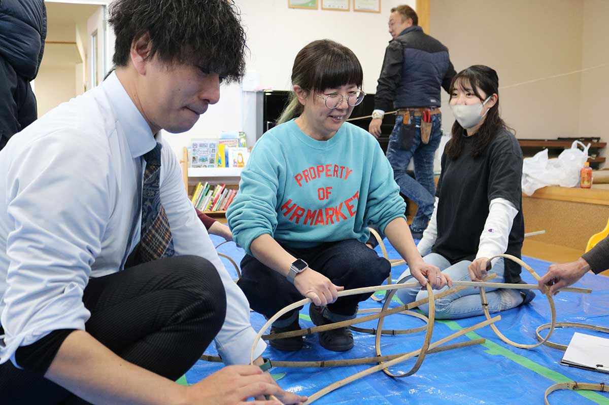 岐阜メンバーの馬淵弥保さん（左から2人目）から竹の組み立て方を教わりながら作業する釜石の協力者