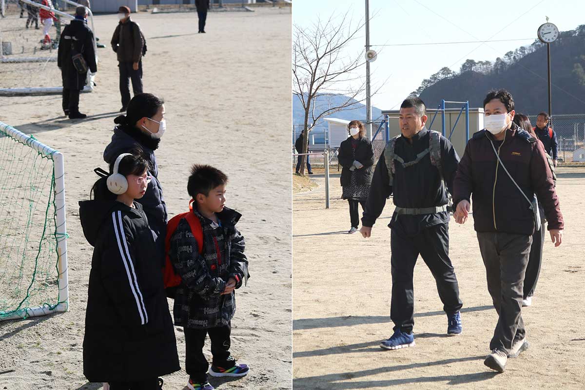 （訓練）地震発生から13分が経過。校庭に続々と避難者が集まる