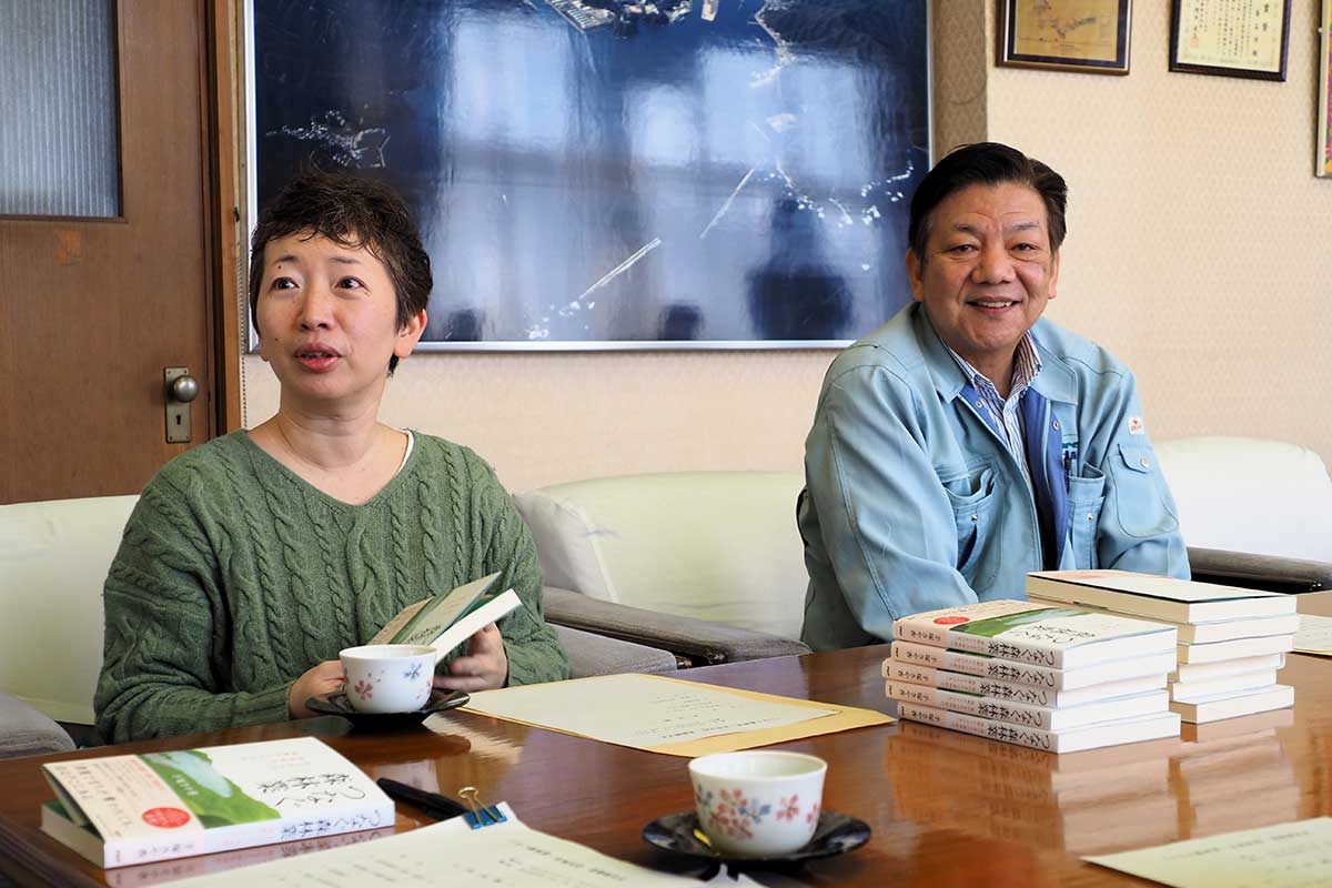 市役所を訪れて本の説明をする手塚さんと高橋参事