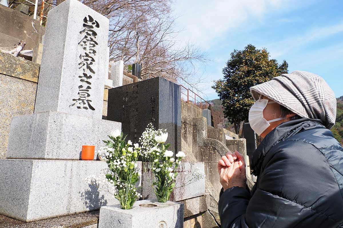 震災で亡くなった夫が眠る墓に話しかける岩舘マユ子さん