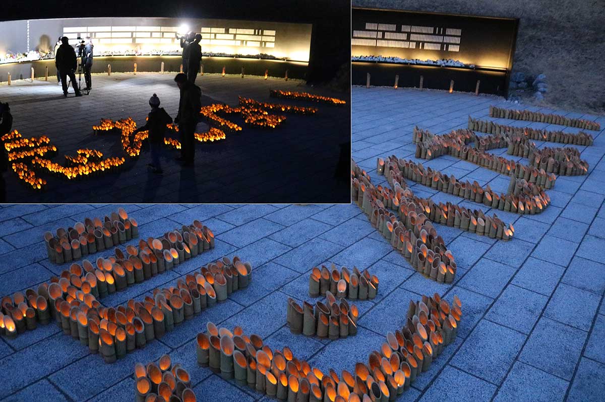 釜石祈りのパークで行われた竹灯籠供養。芳名板の前に「忘れない」の文字が浮かび上がった＝11日夜