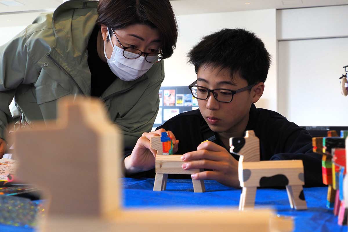 馬の人形に色を塗る作業に熱中する参加者