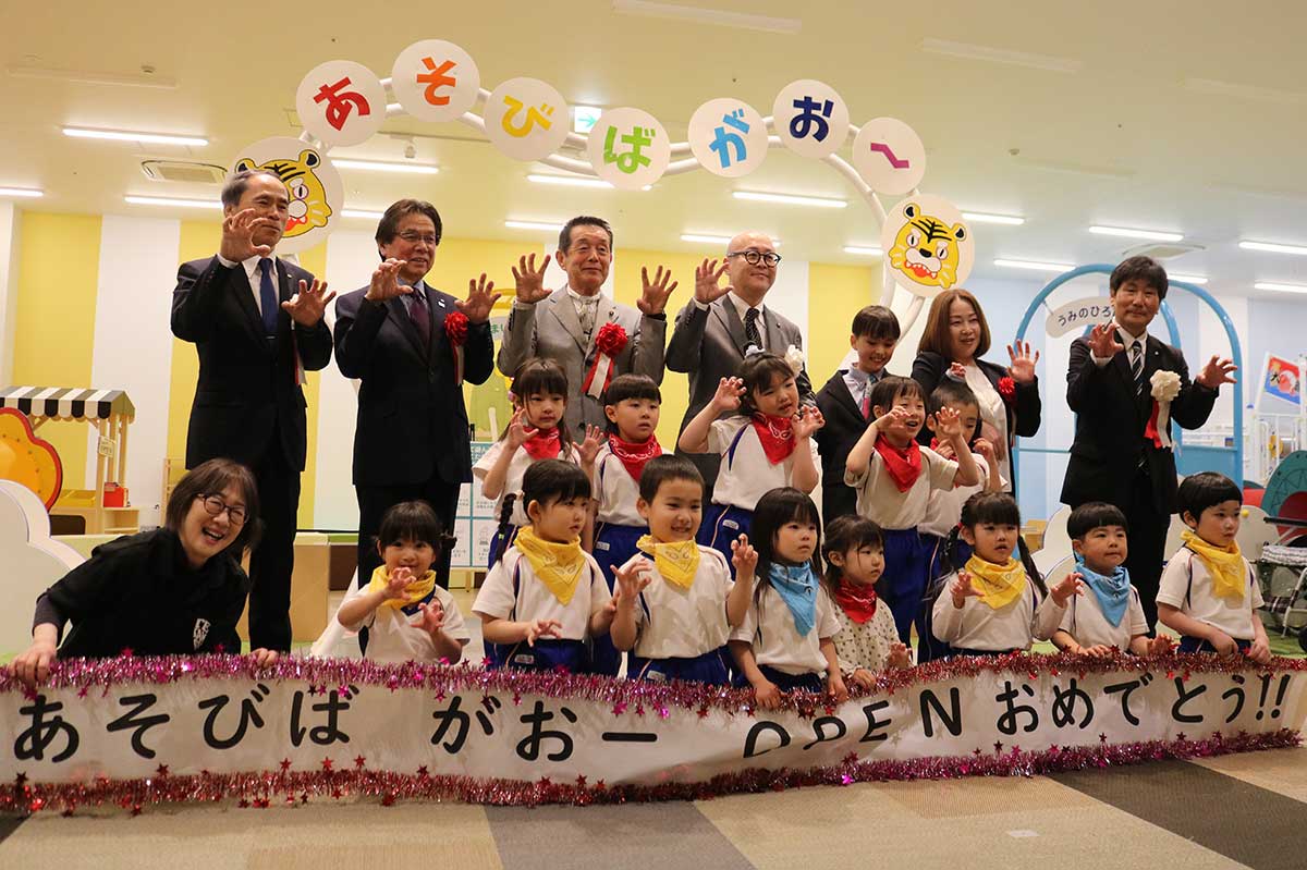 室内遊び場のオープンを「がおー」ポーズで祝うセレモニー出席者