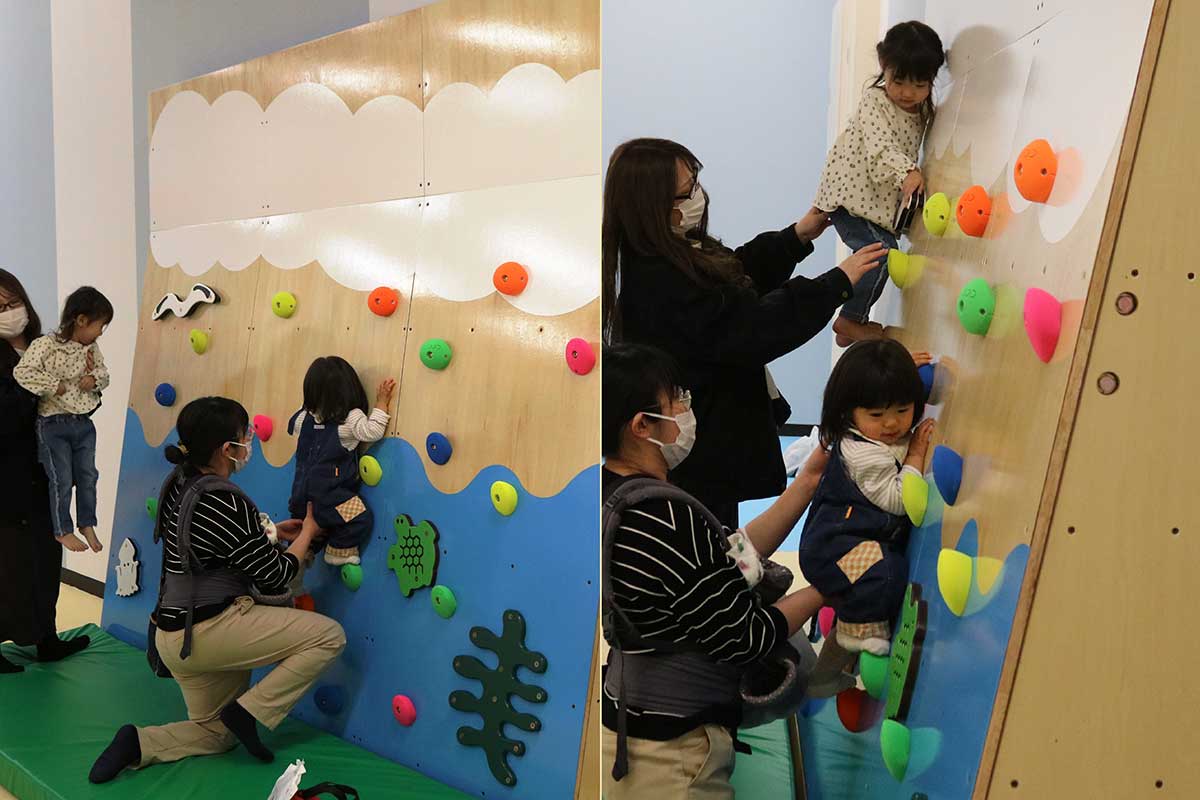 ウォールクライムを楽しむ親子。お母さんに支えてもらいよじ登る
