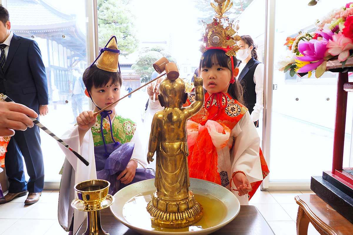 “ののさま”にひしゃくで甘茶をかける園児