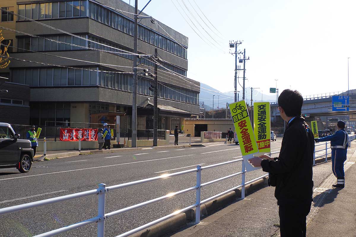 国道283号沿いの歩道に立ち手持ち看板を掲げて啓発