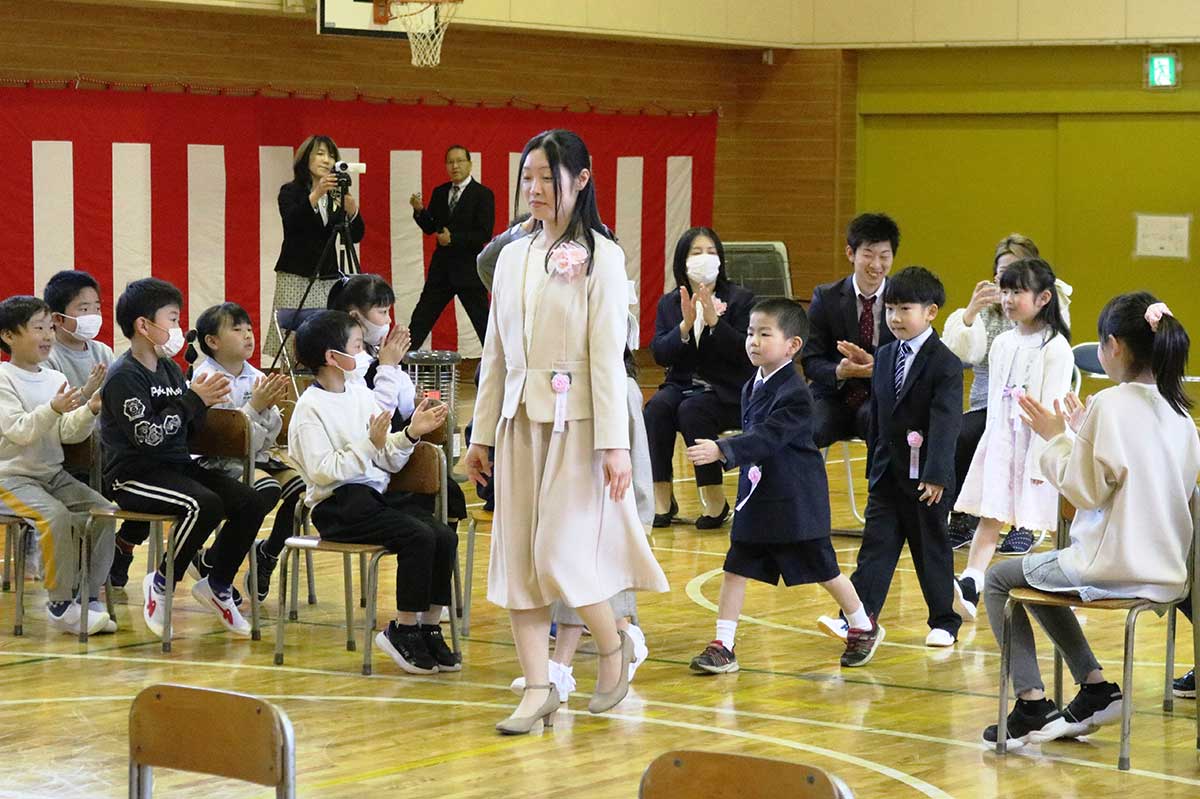 在校生や保護者の拍手に迎えられ入学式会場の体育館に入場