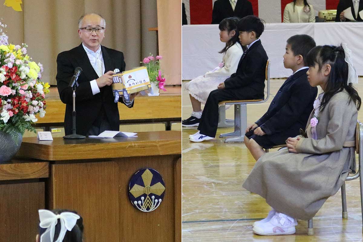 高橋昭英校長（左）は児童全員が乗る未来行きバス「栗っ子号」のクラフトを見せながらあいさつ