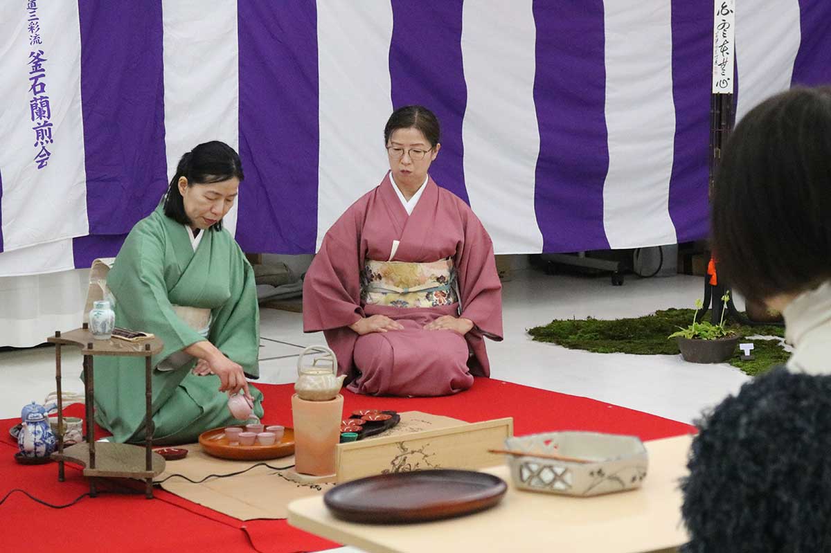 明るい色合いの茶器でお点前。会員の美しい所作に客の視線が注がれる