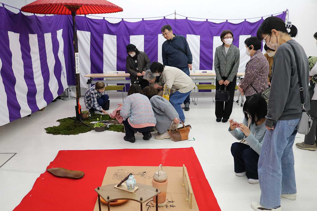 お茶をいただいた後は、茶器などを拝見。スマホカメラで写真を撮る人も width=