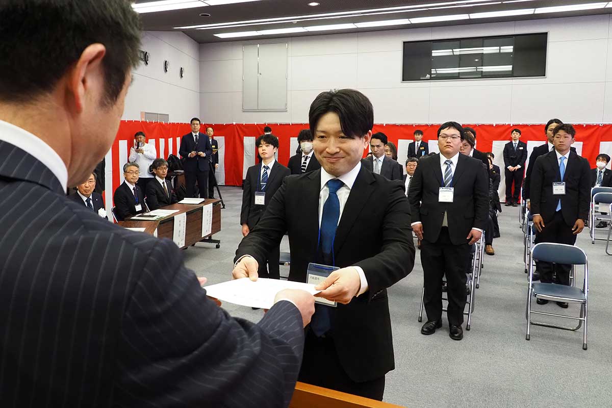 研修生を代表し研修許可証を受け取る浦嶋孝行さん