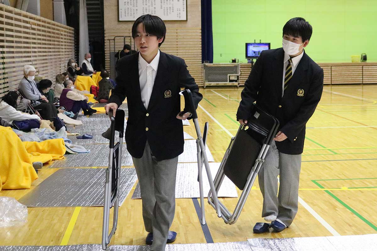体育館内で必要な人にパイプ椅子を配る東中出身の大槌高生