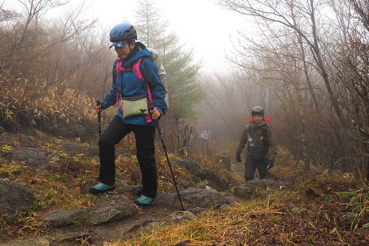 足元に気を配りながら力強い一歩を踏み出す登山者