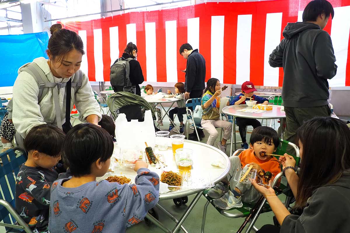 焼き物やドリンクなどを味わう親子連れ