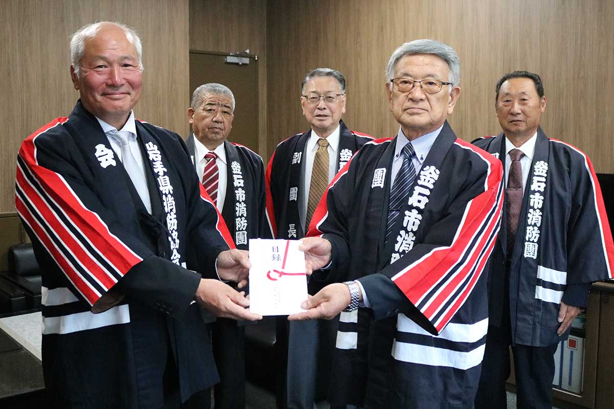 日本消防協会からの災害対策支援金の目録を釜石市消防団の菊池録郎団長（前列右）に手渡す岩手県消防協会の高橋信博会長（同左）