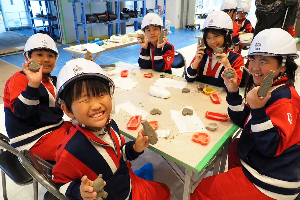 完成した作品を手に笑顔を見せる子どもたち