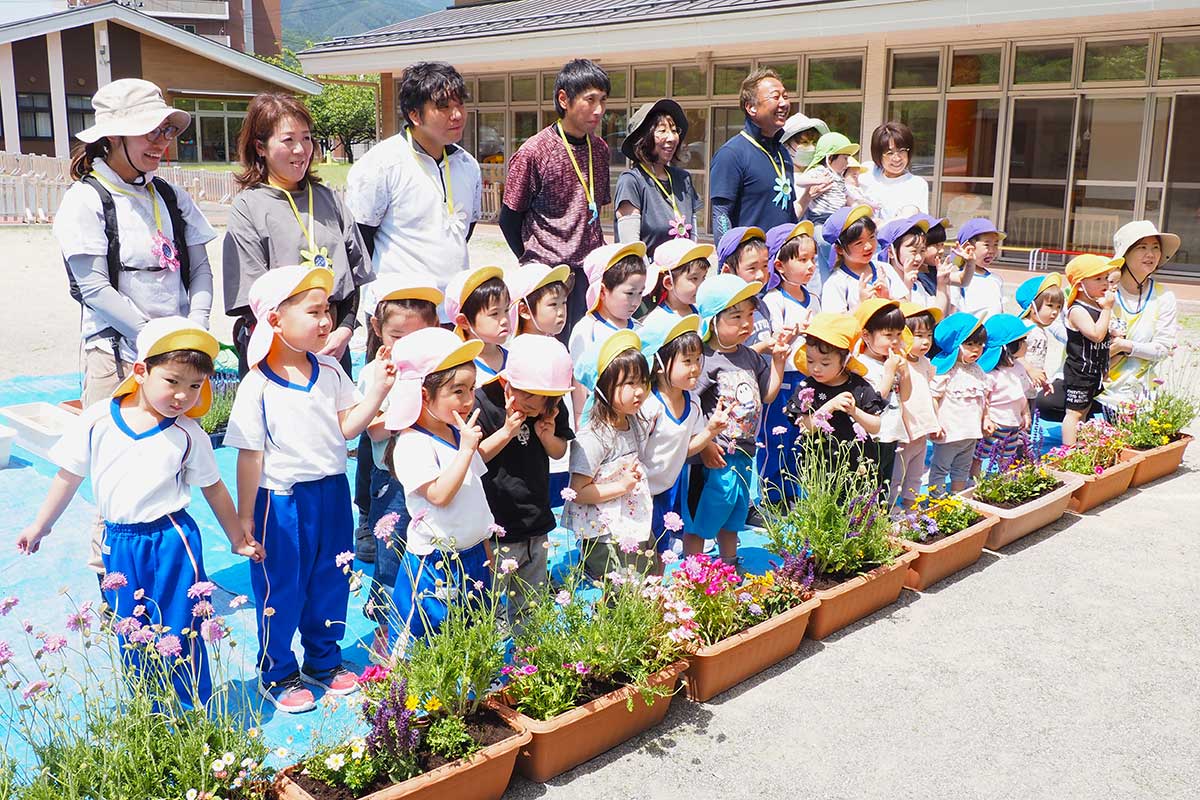 「お花でいっぱい」と満足げに写真に納まる植栽活動の参加者