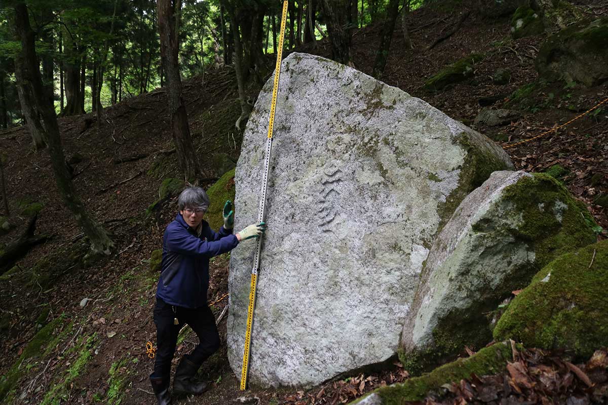 開山碑は人の背丈を超える大きさ。文字が刻まれている面は所々コケに覆われていた