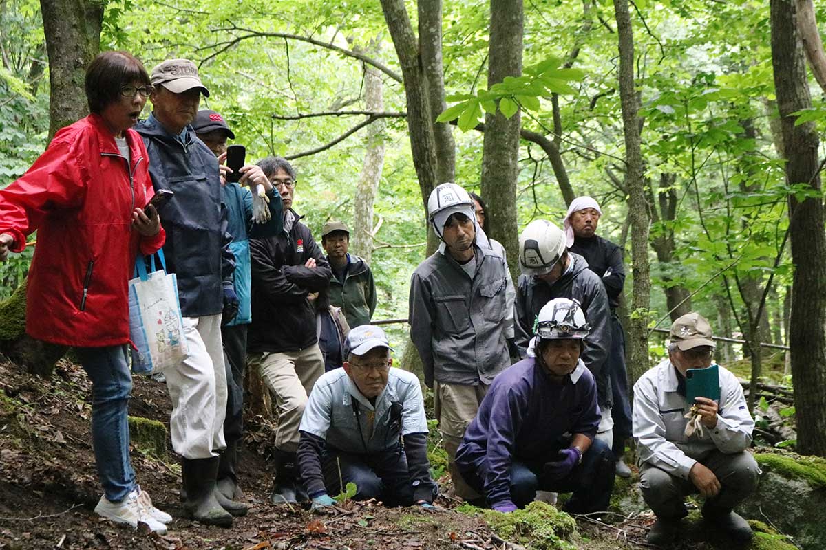 髙橋岳係長の解説を聞きながら開山碑に目がくぎ付けとなる参加者