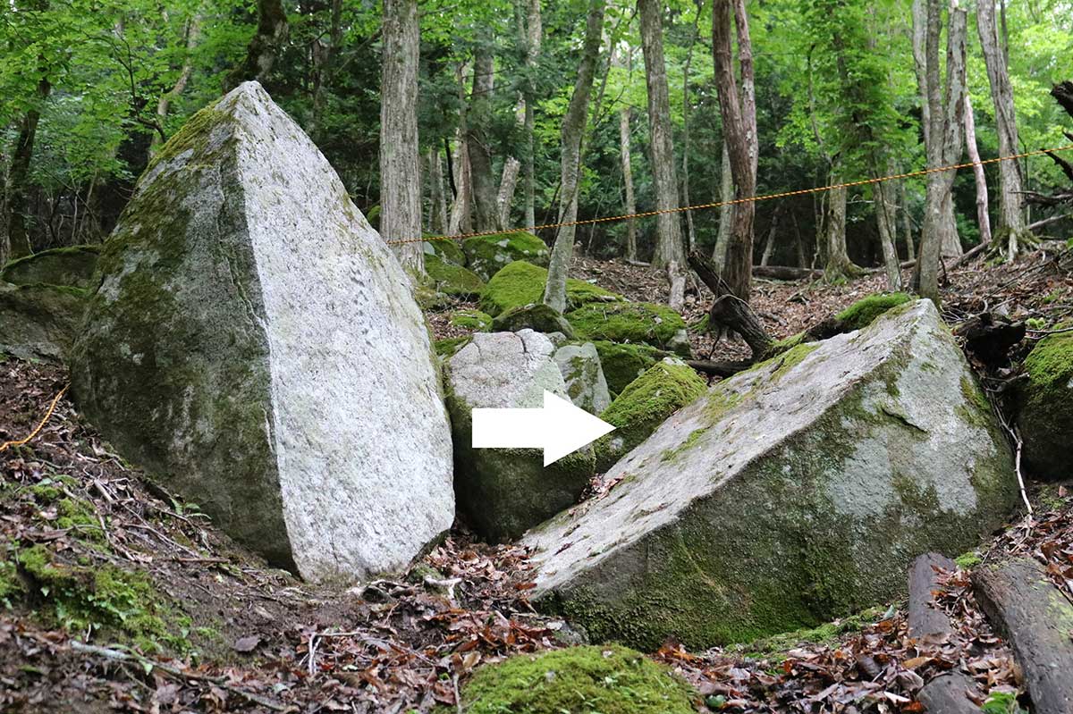 対面に横たわっているのが割れた岩の片割れとみられる（白矢印）