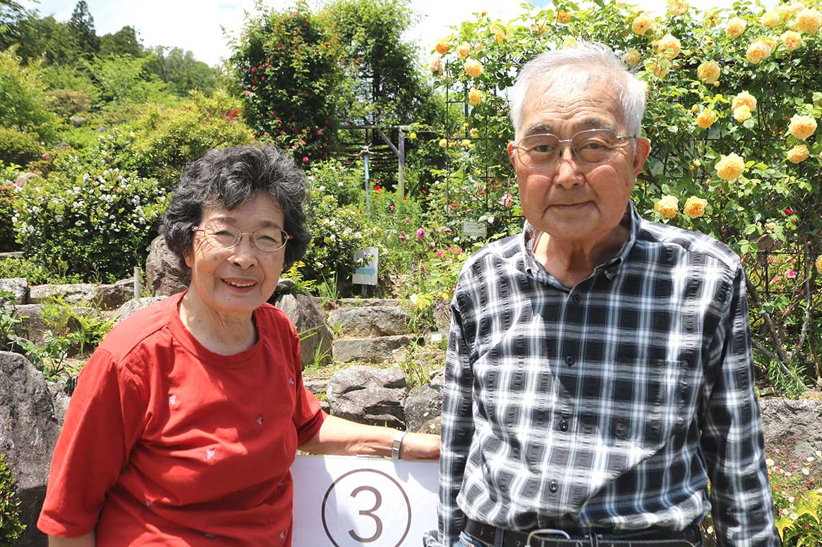 オープンガーデンで見学者を迎える菊池秀明さん(右)、陽子さん夫妻