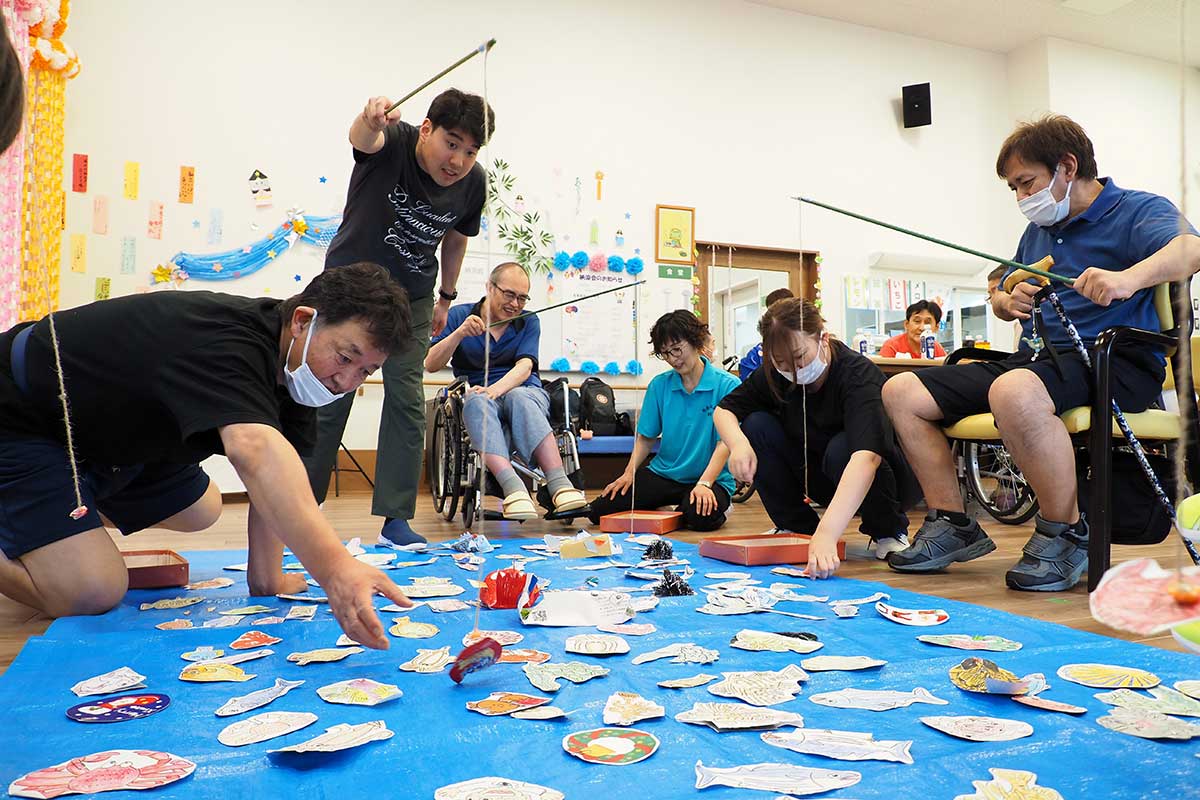 狙いを定めて一投。手作りの魚釣りゲームに熱中