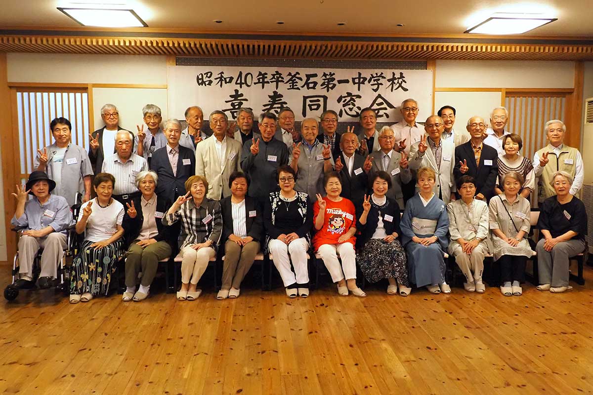 各地から古里に集った同級生はピースサインで集合写真に納まる