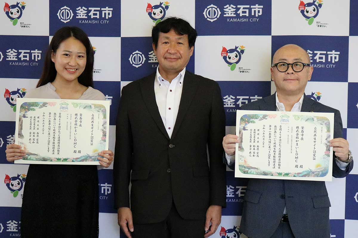 環境省東北環境局の東岡礼治局長（中）から「自然共生サイト」の認定証を受け取った釜石市の小野共市長（右）、かまいしDMCの村上舞子さん（左）