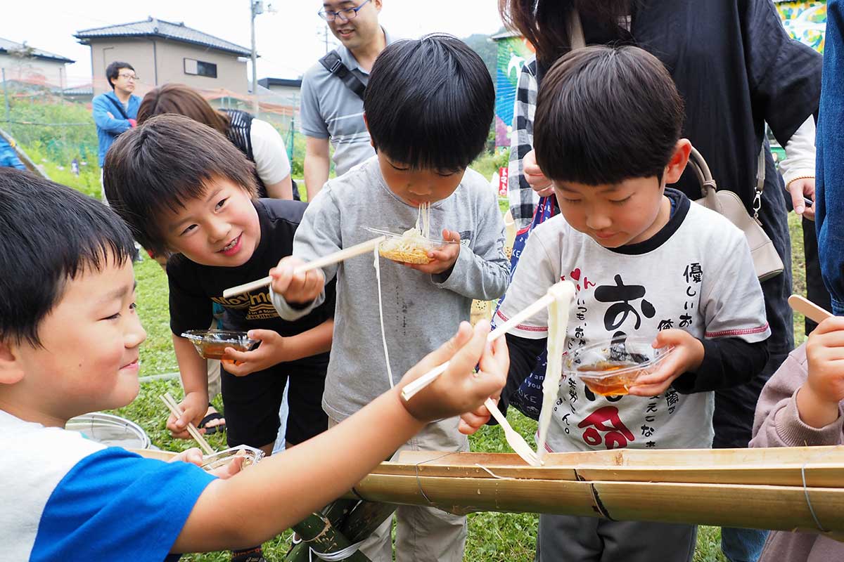 流しそうめんに夢中になる子どもたち。ウキウキ顔で待ち構える
