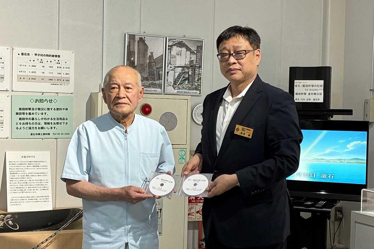 釜石艦砲射撃のアニメーションDVDを手にする庄子忠良会長(左)、髙橋勝教育長=7月30日、釜石市提供