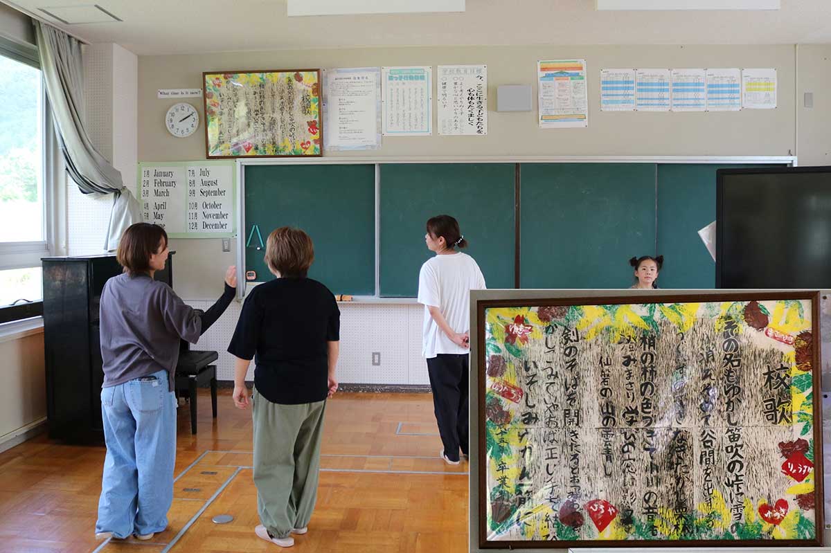 「校歌、覚えてる？」 卒業制作作品の校歌の版画（右下拡大）を見上げる見学者＝視聴覚室