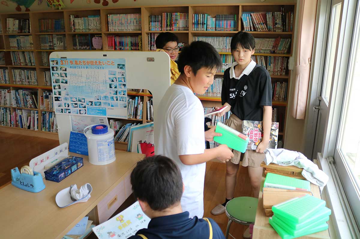 図書室で在校時の思い出に浸る釜石東中生。それほど年数がたたずとも「なつかしー！」