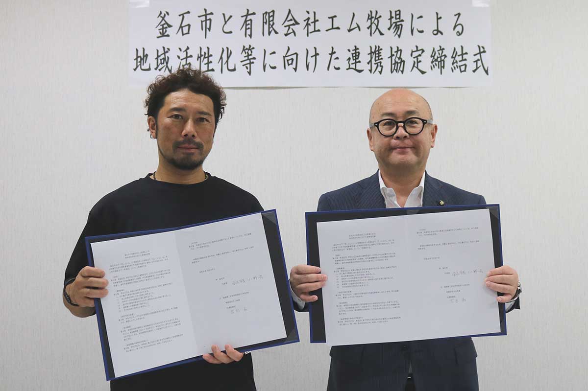 署名した協定書を取り交わしたエム牧場の吉田和代表取締役（左）と釜石市の小野共市長