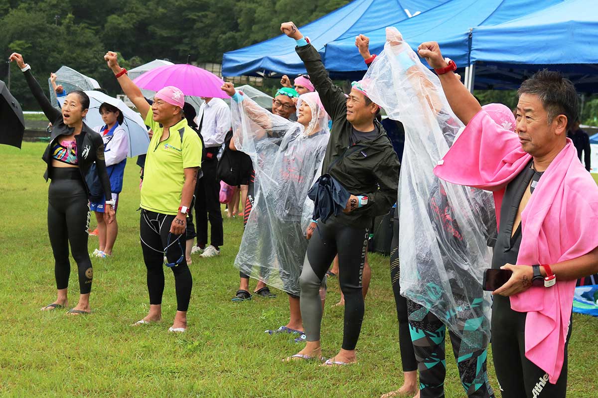 あいにくの雨を吹き飛ばす元気な掛け声で気合い入れを行う選手ら