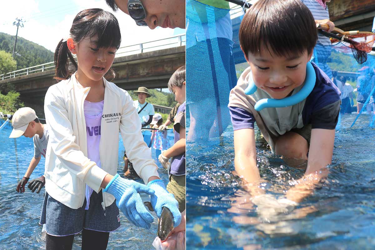 水の中にそーっと手を伸ばしタイミングを見計らってぎゅっ！ とった魚は家族が持つビニール袋にIN