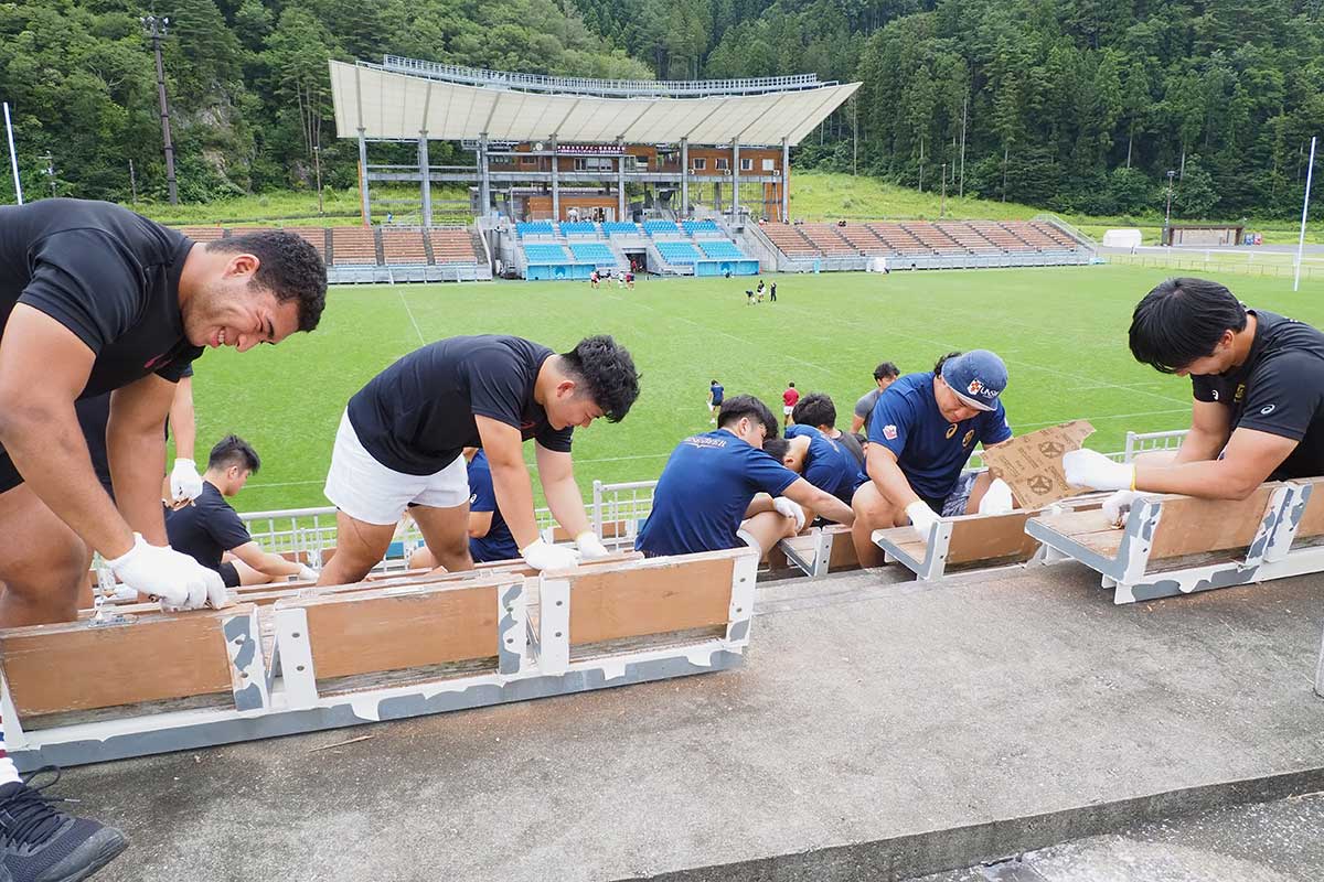 釜石合宿の拠点となったスタジアムに感謝を込めベンチをやすりで磨いた＝7月31日