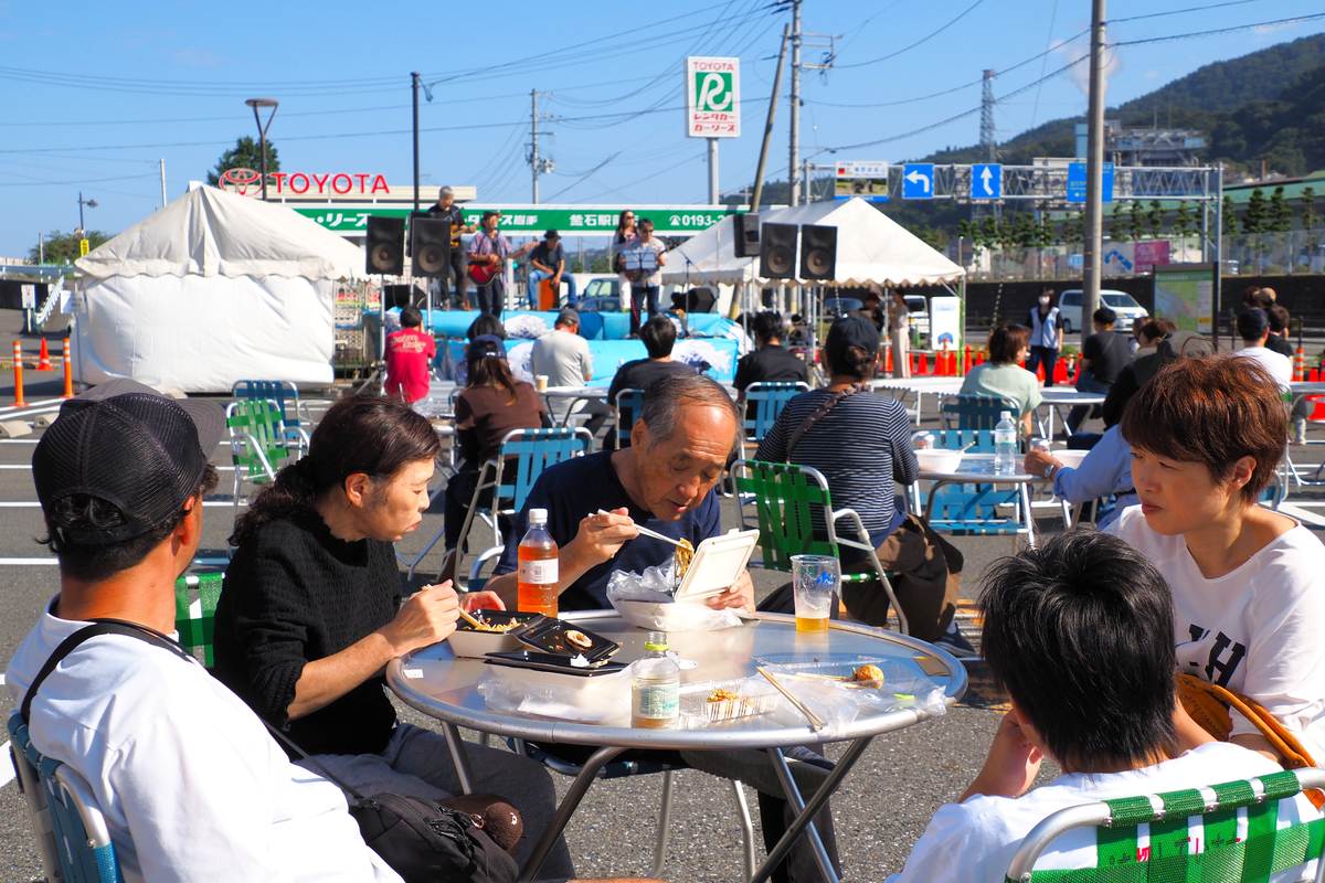 バンド演奏を聴きながらおいしいものを味わう人たち