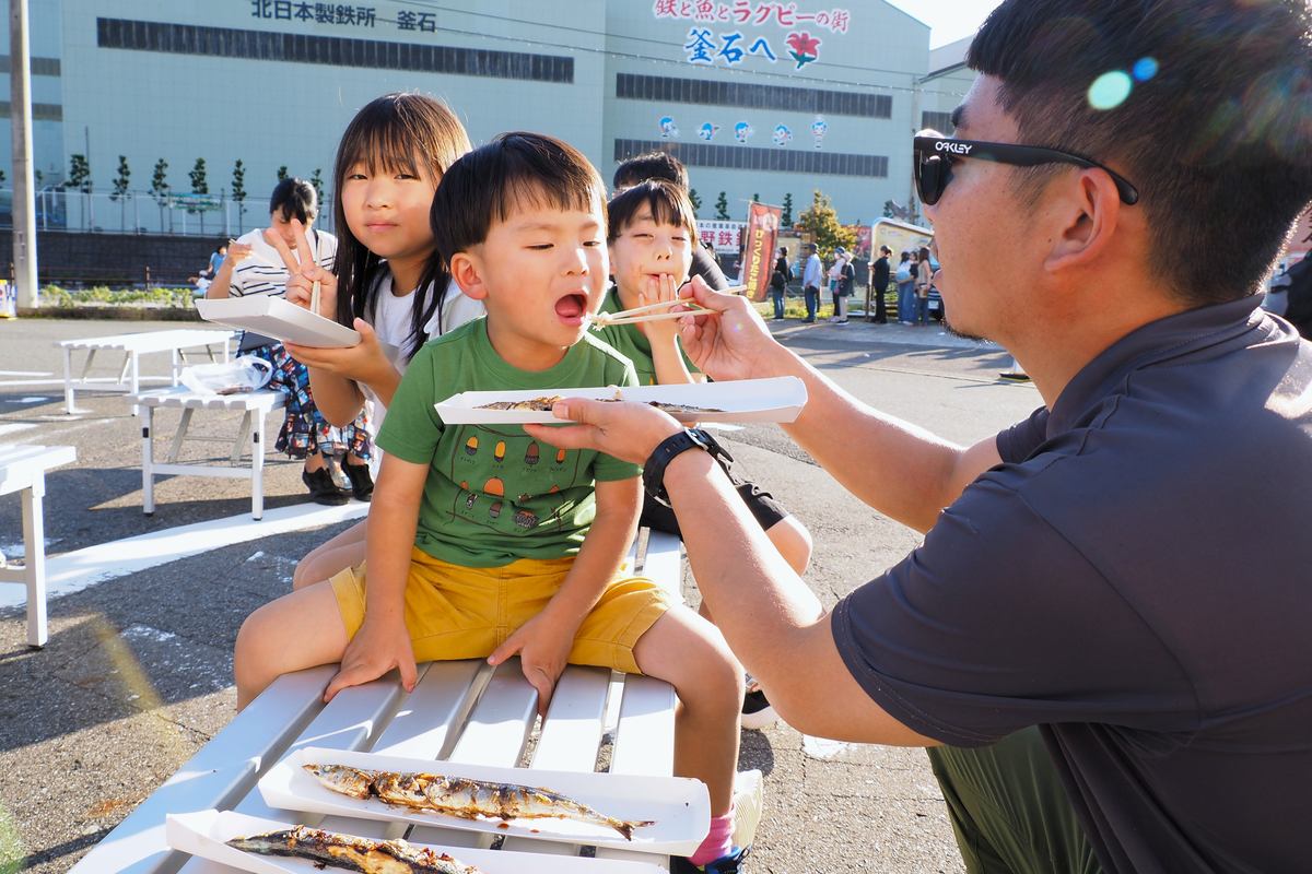 サンマを頬張り「おいしい」と喜ぶ家族連れ