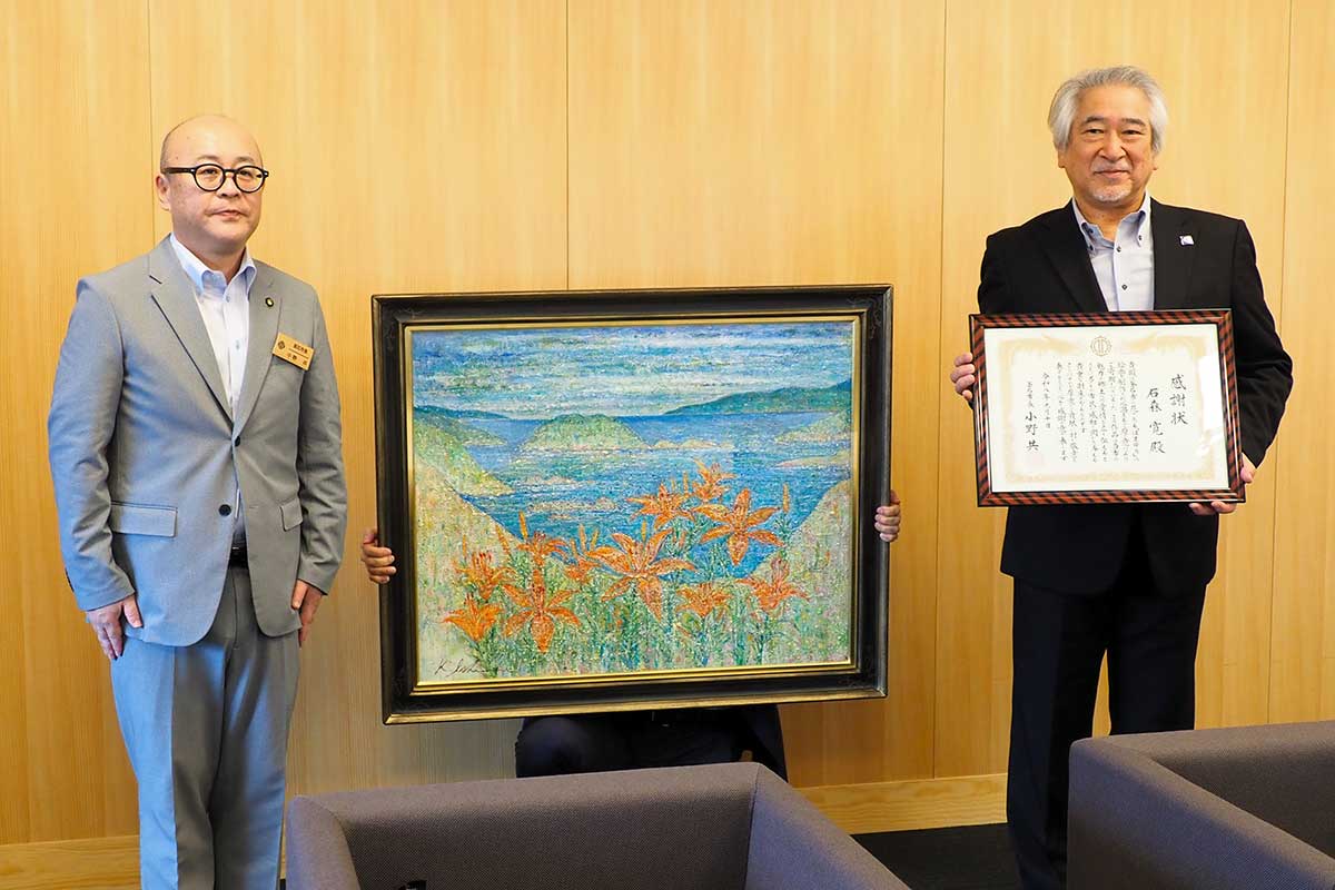 新市庁舎の完成を祝い絵画を寄贈した石森寛さん(右)