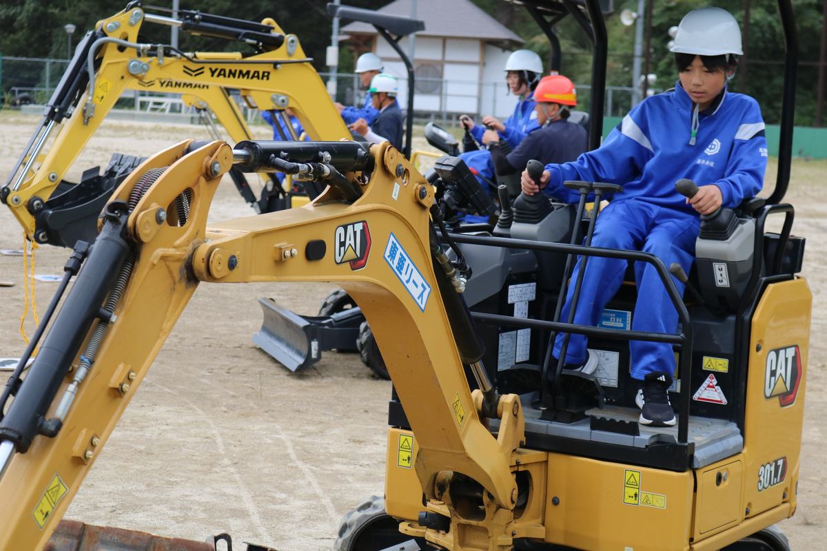 県建設業協会釜石支部青年部の「ふれあい事業」で重機操作を体験する釜石東中の1年生