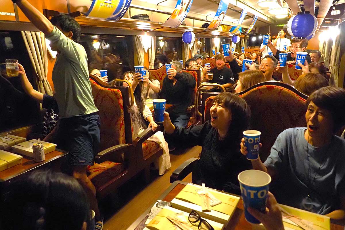 かけ声は「スコール！」。ビールを片手に乾杯をする乗客たち