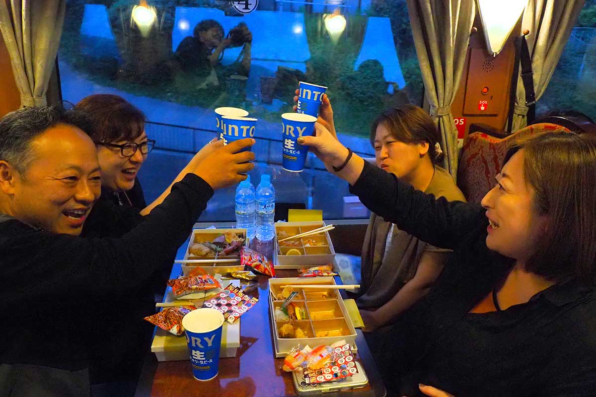 「スコール！」。乾杯を楽しむ声が幾度も車内に響く