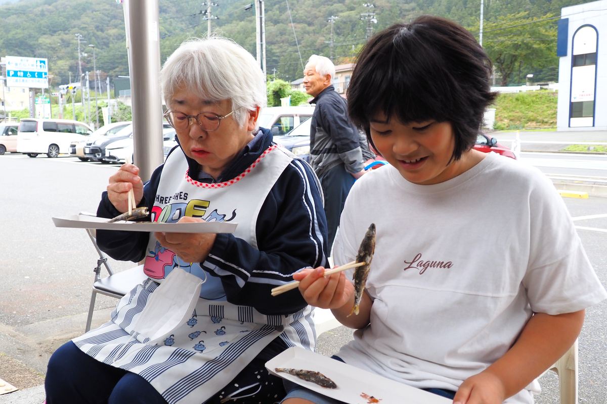 アユの塩焼きをうれしそうに味わう家族連れ
