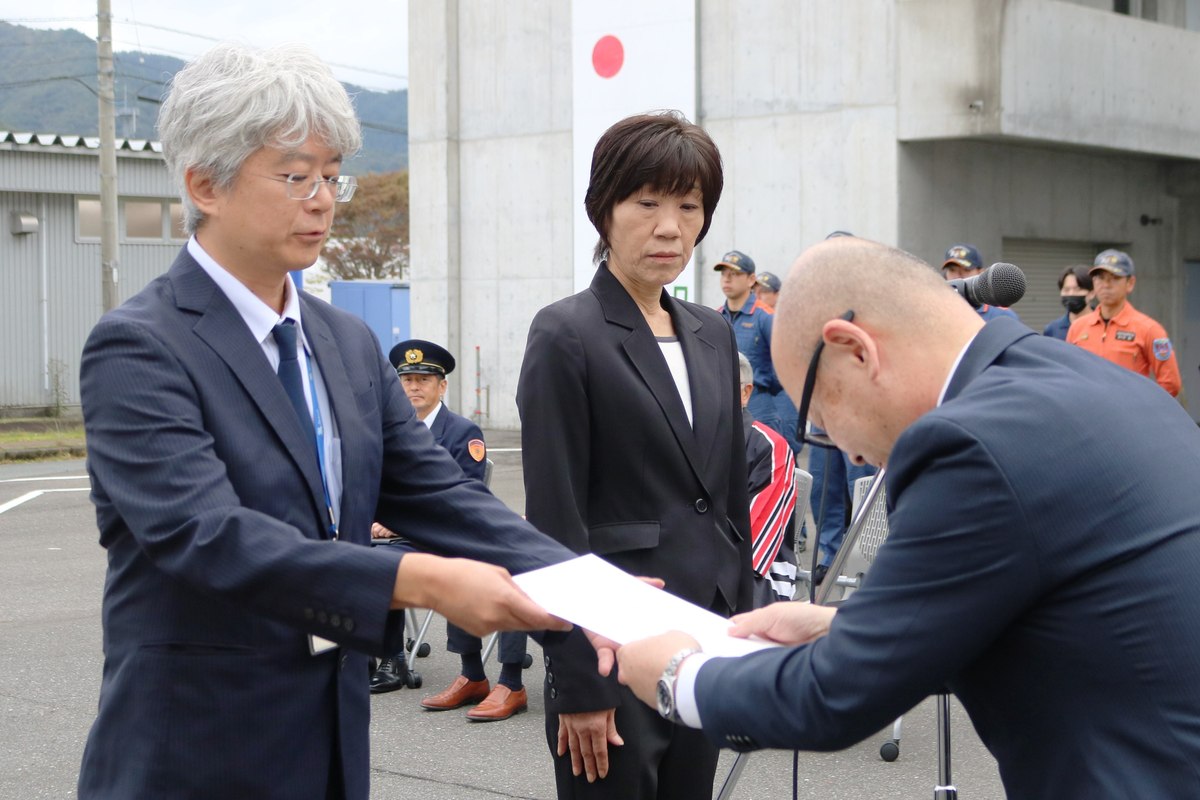 小野共市長から消防団協力事業所の交付書を受け取る岩手旅行社の菊池直樹代表取締役（左）