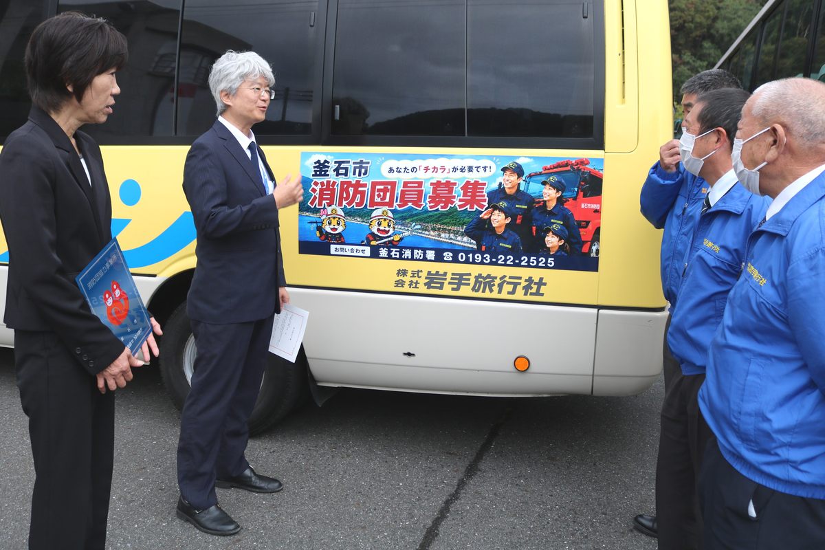 バスのドライバーら（右側）とステッカーを貼った車両を確認する菊池代表取締役（左から2人目）