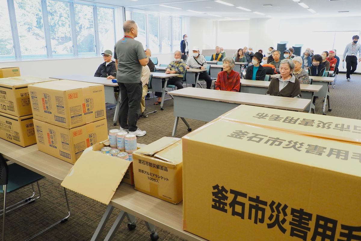 大会議室で市職員から災害備蓄品などの説明を聞いた